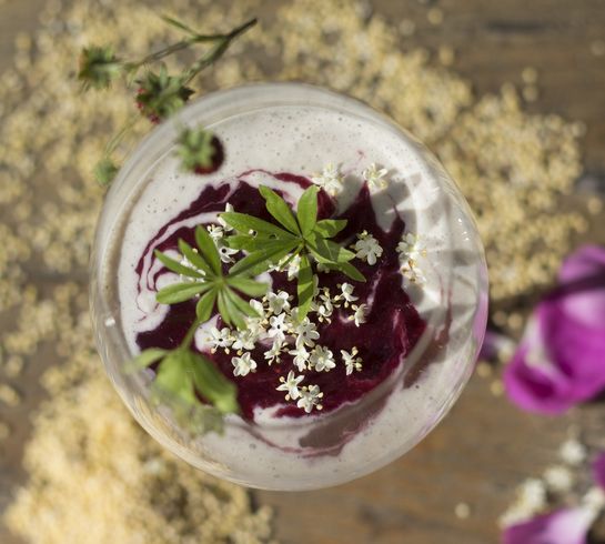 Hirsecreme im Glas mit lila Blüten garniert 